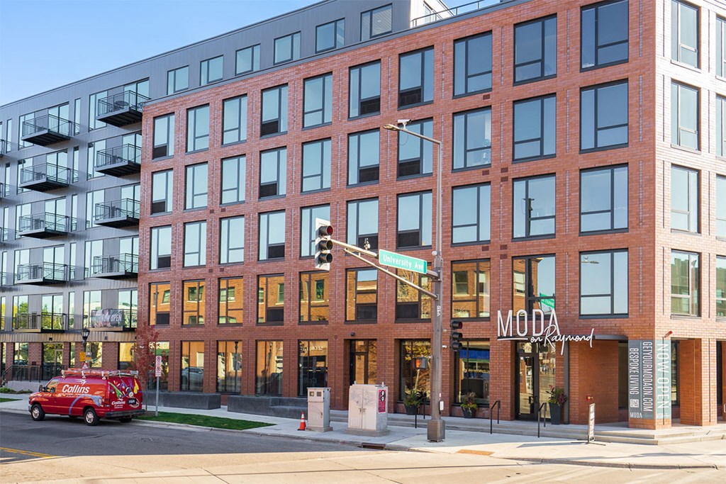 A red fire truck is parked in front of a building with a sign that says "MODA".