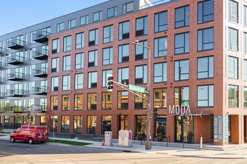 A red fire truck is parked in front of a building with a sign that says "MODA".