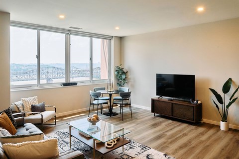 A living room with a glass coffee table and a television.