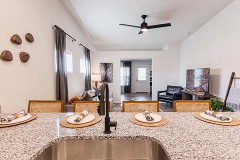 A kitchen with a table set for two with plates and cutlery.