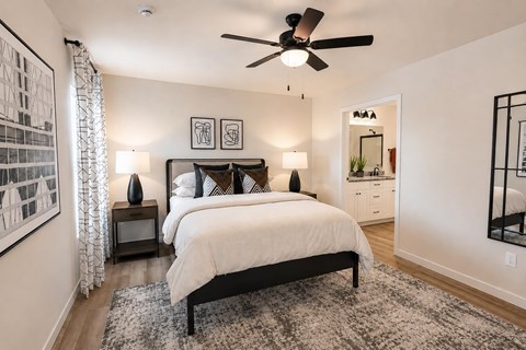 A bedroom with a large bed and a ceiling fan.