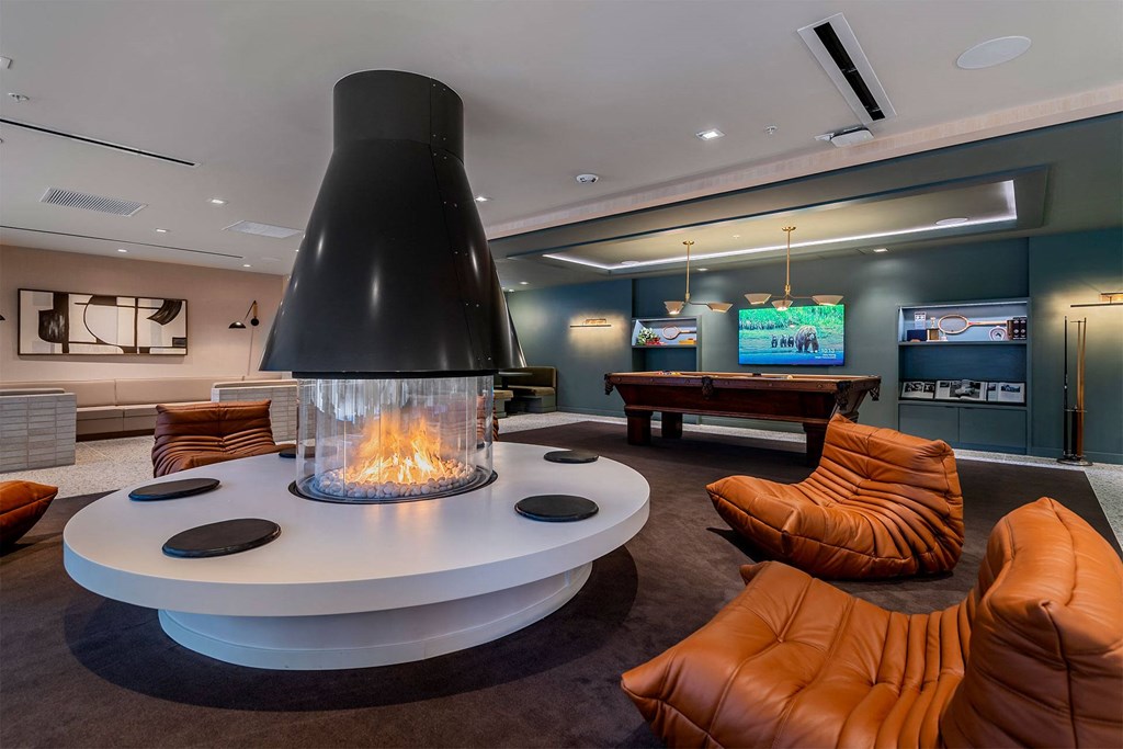 A modern living room with a fireplace and orange chairs.