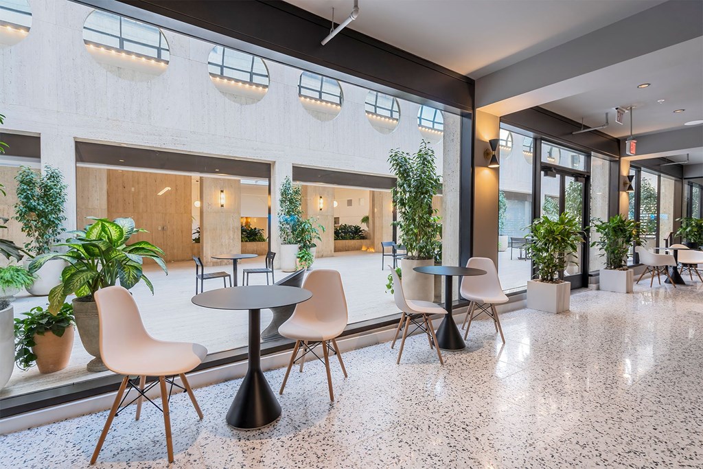 A white and black marble floor with a round table and chairs.