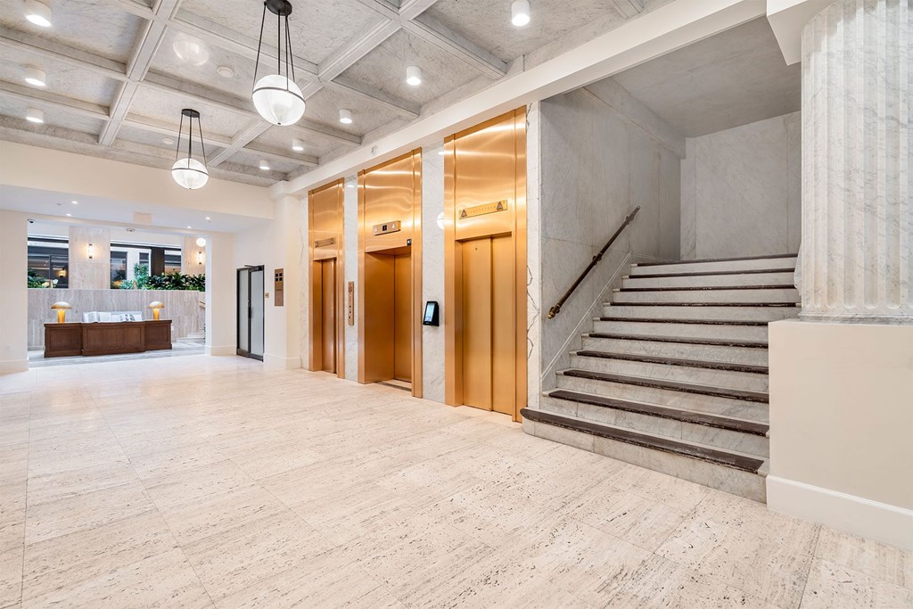 A spacious hallway with a staircase and a reception desk.