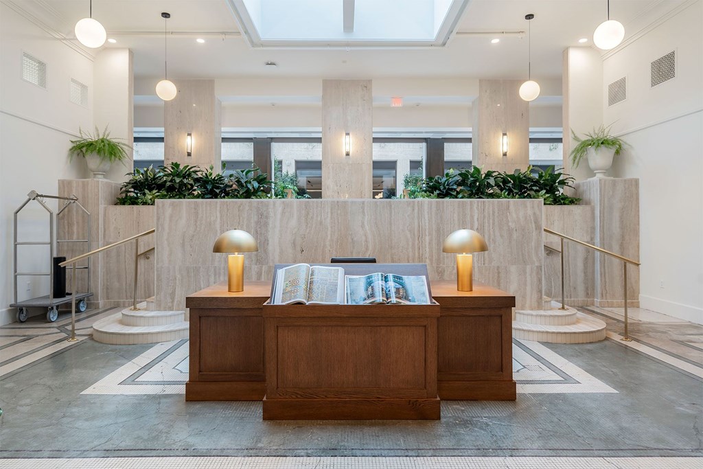 A reception area with a wooden desk and two lamps.