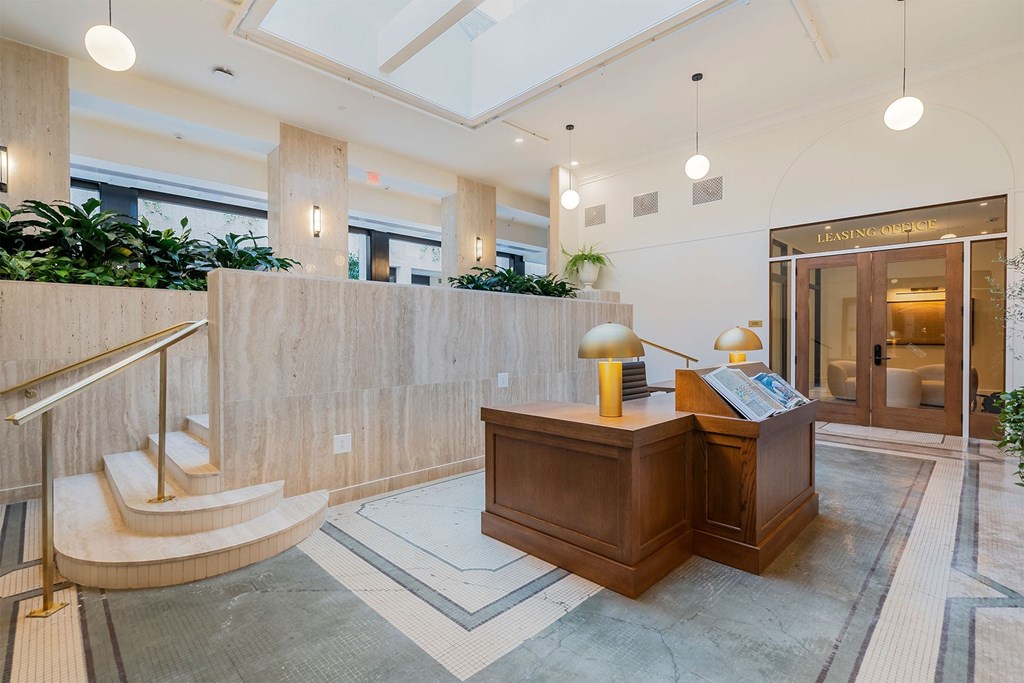 A reception area with a wooden desk and a staircase.