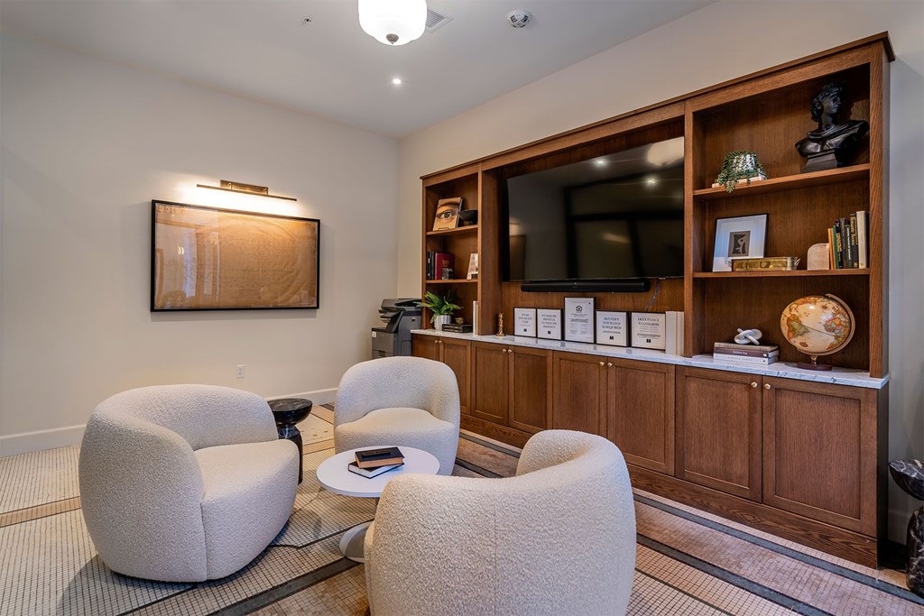 A living room with a grey chair and a brown cabinet.