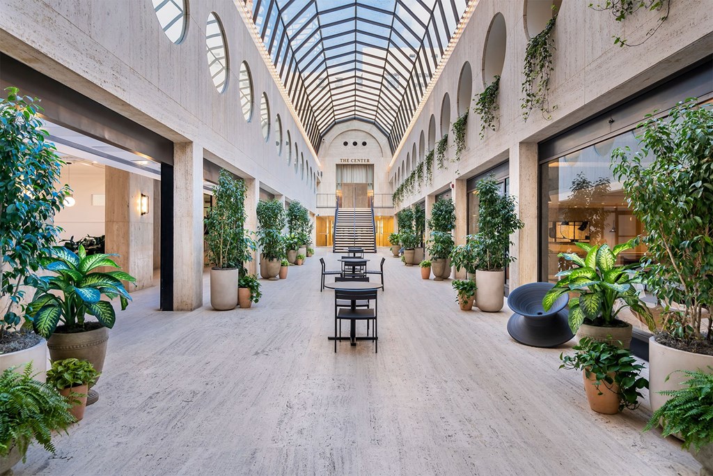 A long hallway with a table and chairs in the middle.