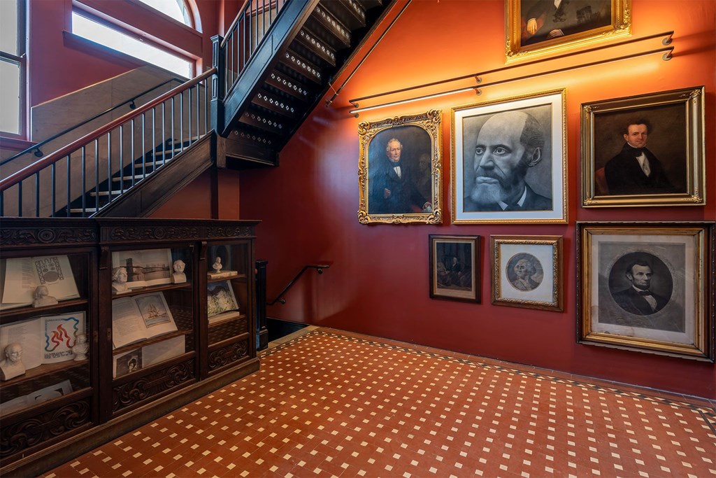 A staircase with a red wall and a picture of a man on it.