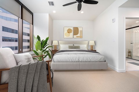 A bedroom with a large bed and a ceiling fan.