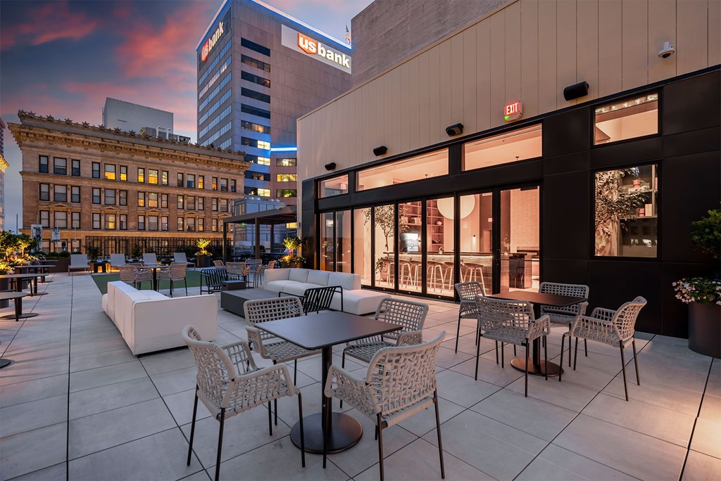 A patio with tables and chairs is set up outside a building with a US Bank sign.
