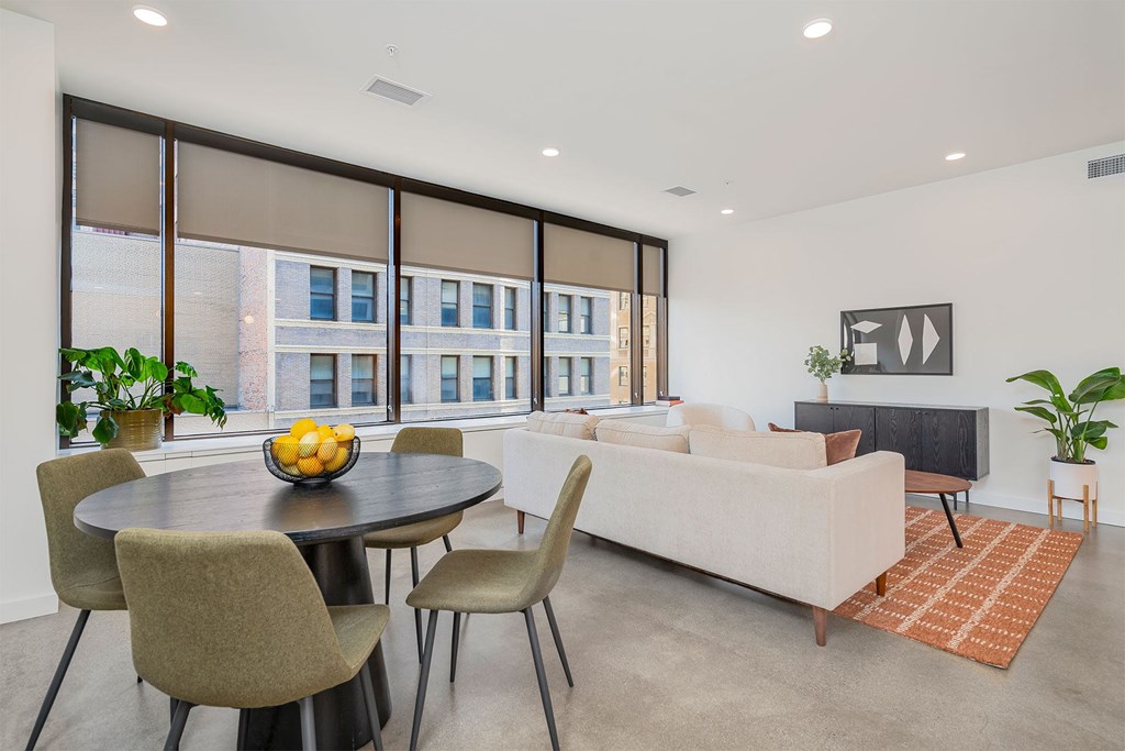 A modern living room with a dining table and chairs.