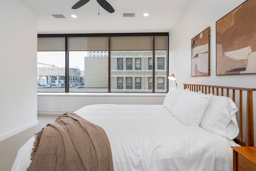 A bedroom with a large bed and a ceiling fan.