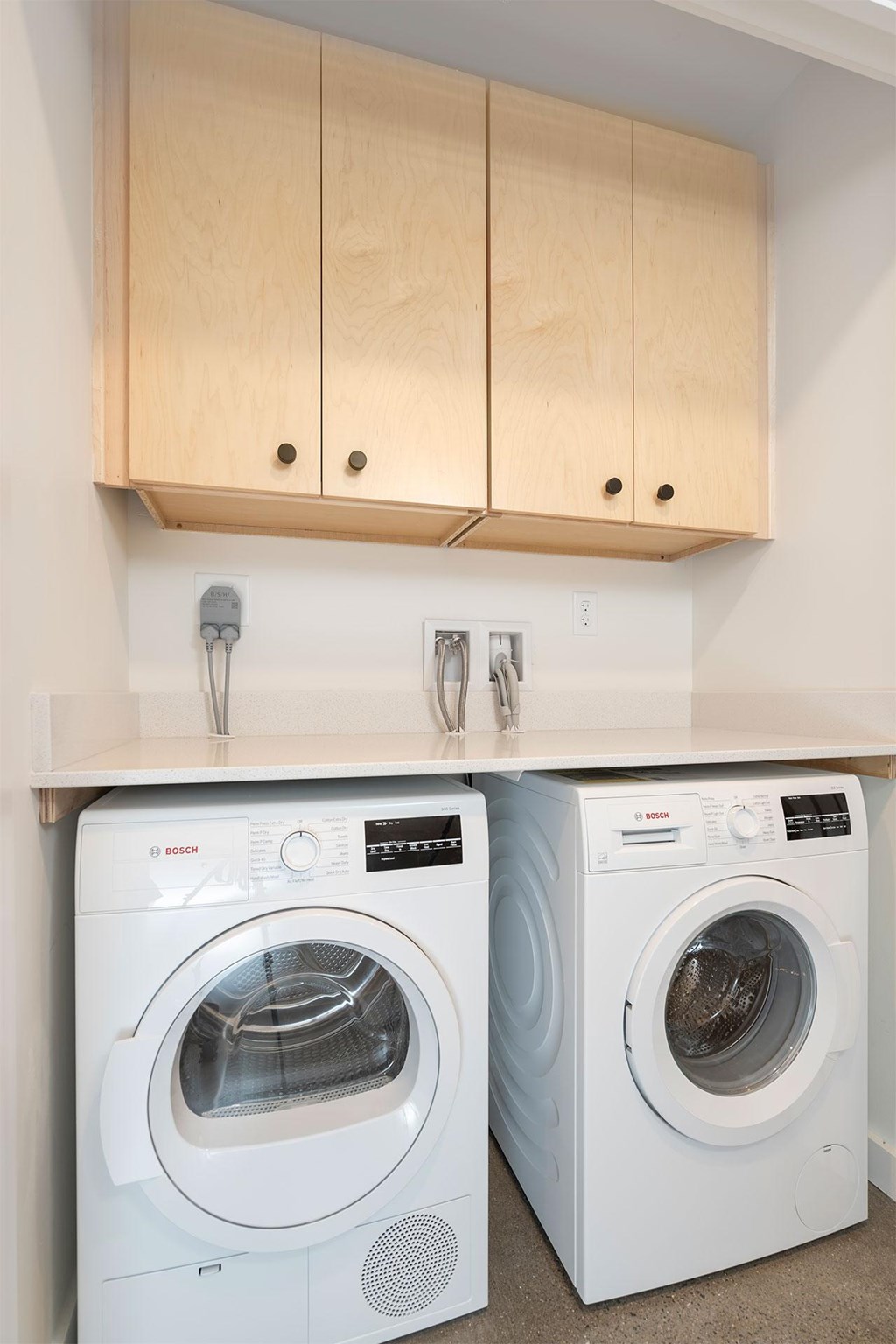 Two front loading washing machines in a laundry room.