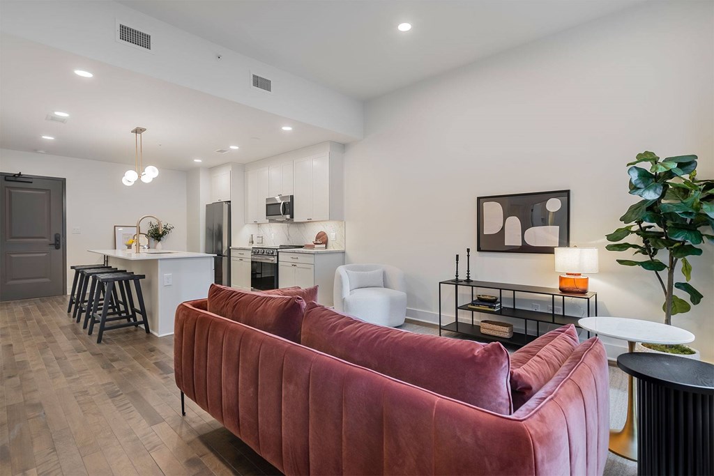 A living room with a red couch and a bar area.