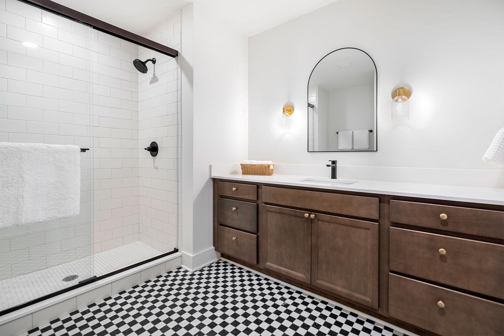 A white bathroom with a black and white checkered floor.