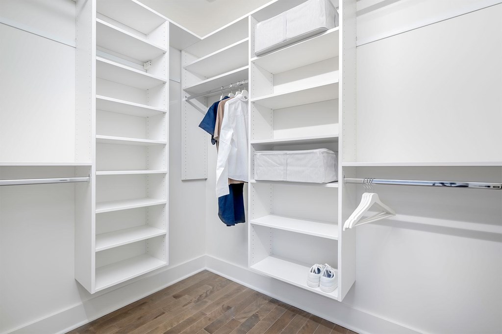 A white closet with a coat hanging on the rod.