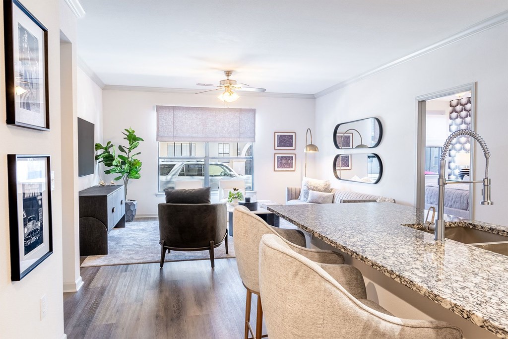 kitchen island with barstools and living room with a chair and window