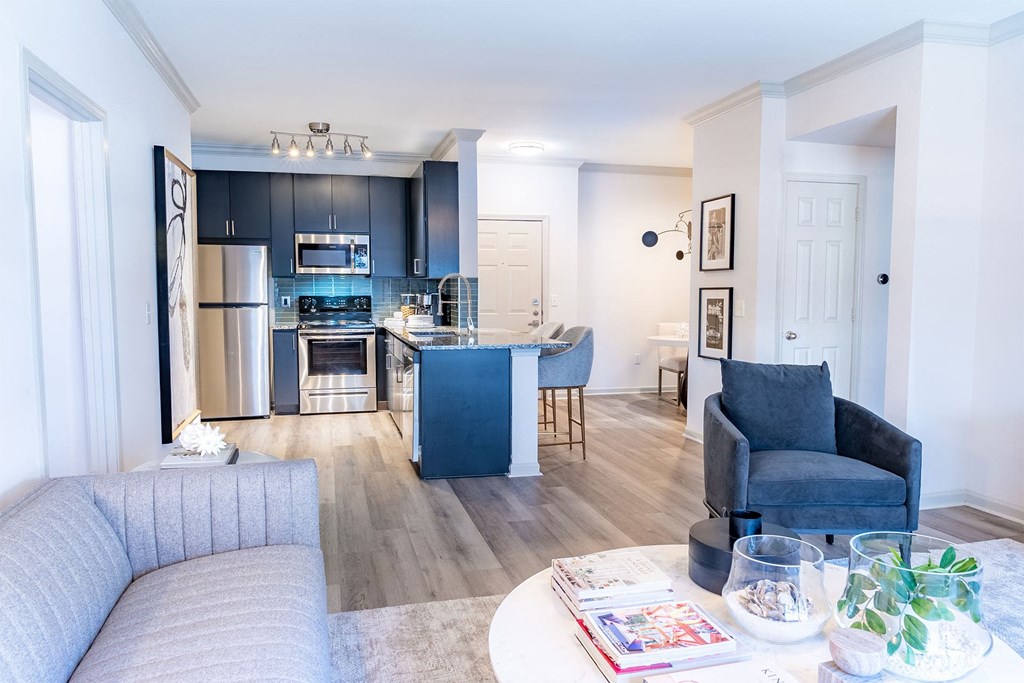 living room with sofa and kitchen with stainless steel appliances