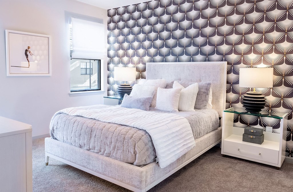 a bedroom with a large bed and a geometric wallpaper