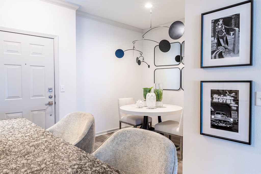 a living room with a table and chairs and a white door
