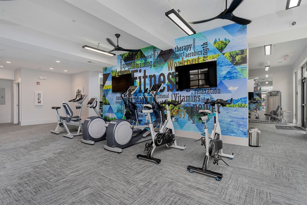 a gym with a wall mural of fitness equipment and weights