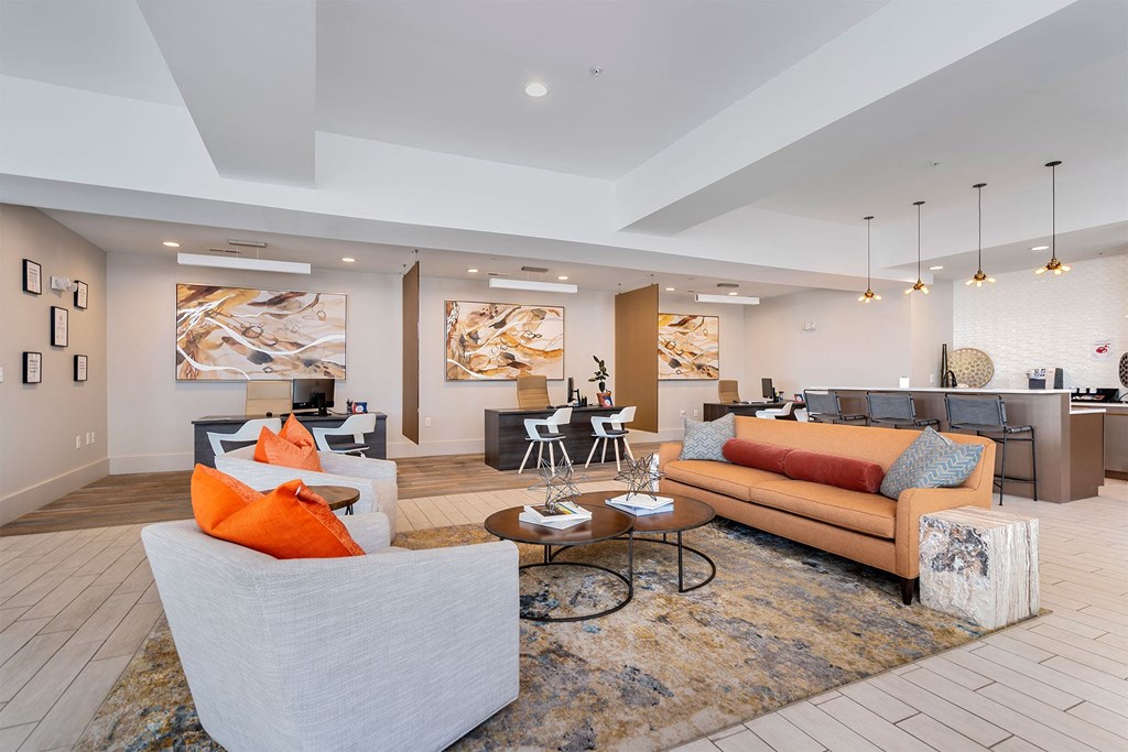a living room with couches and chairs and a kitchen