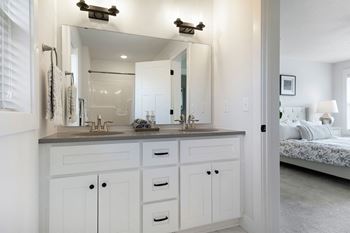 bathroom with a large mirror and a double vanity sink