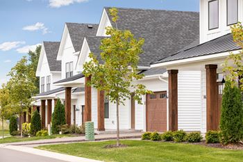 a row of white houses with a sidewalk in front of them