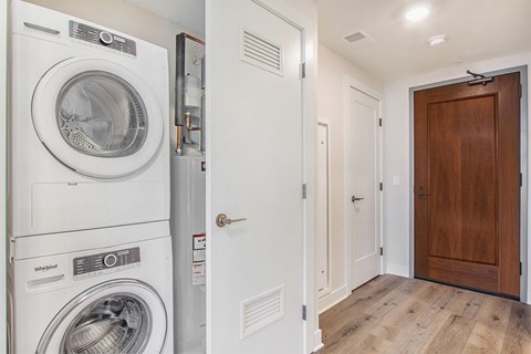A white Whirlpool washing machine and dryer in a small laundry room.