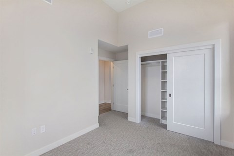 A large, empty room with a carpeted floor and white walls.