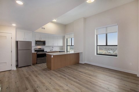 A kitchen with a refrigerator, microwave, and oven.