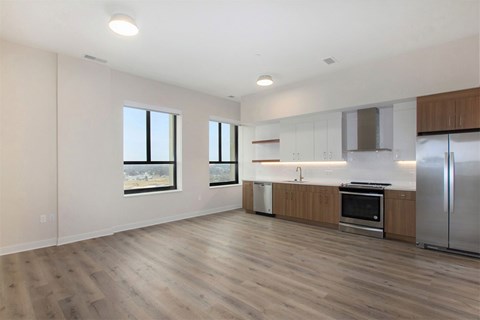 A spacious kitchen with stainless steel appliances and wooden flooring.