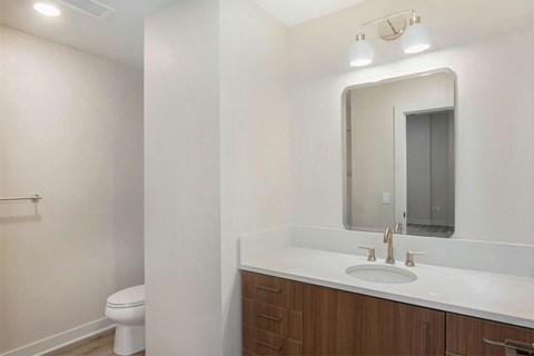 A bathroom with a white counter and a white toilet.