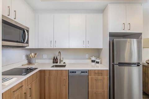 A modern kitchen with a stainless steel refrigerator and wooden cabinets.