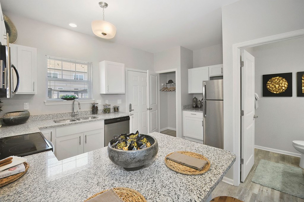 a kitchen with white cabinets and a granite counter top