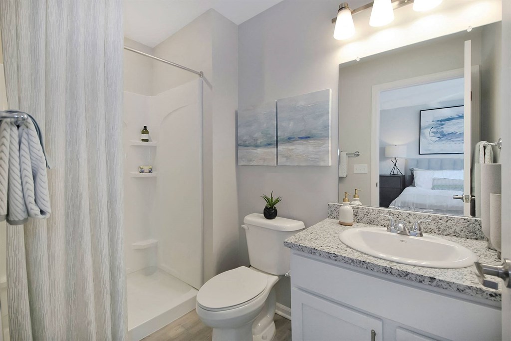 a white bathroom with a mirror and a toilet and a sink