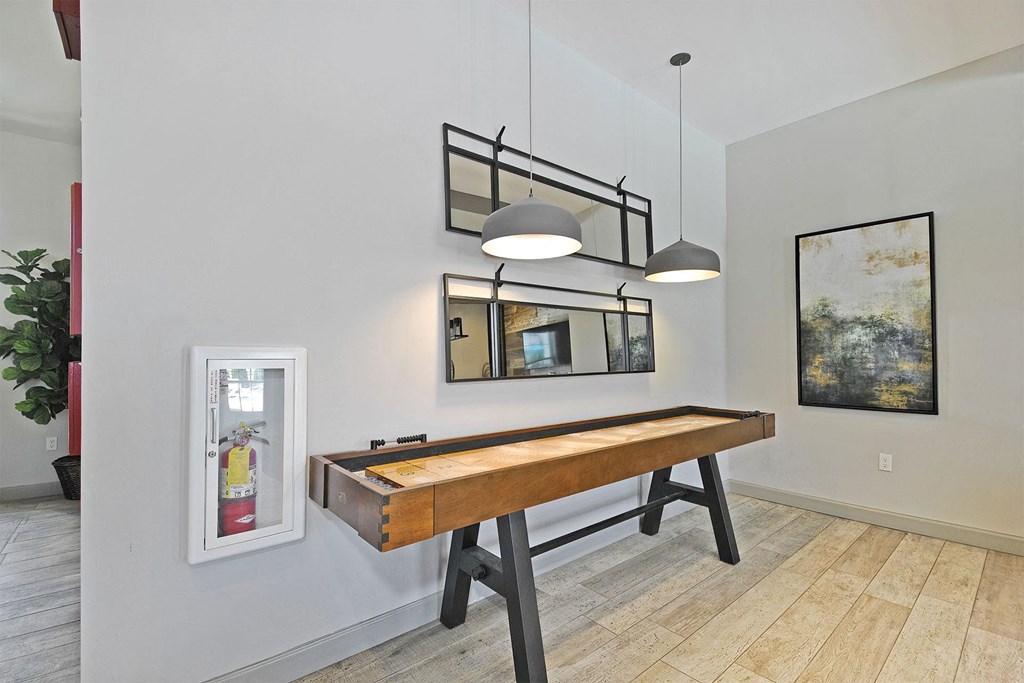 a shuffleboard table in a game room with two lights