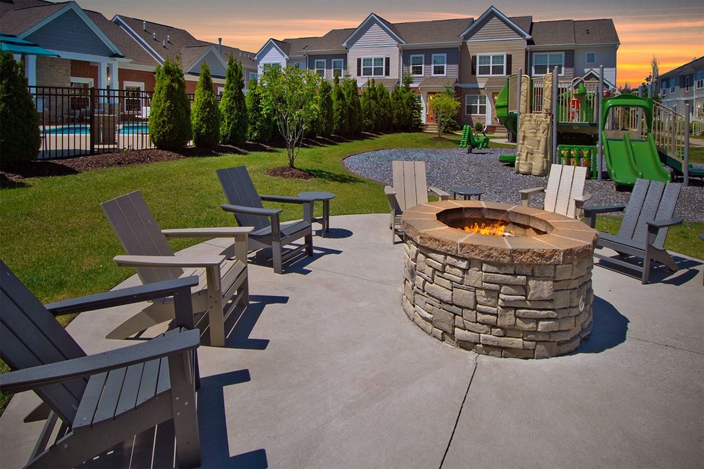 an outdoor patio with a fire pit and benches