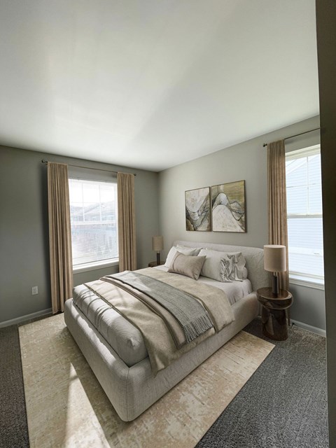 A bedroom with a large bed and a window with curtains.