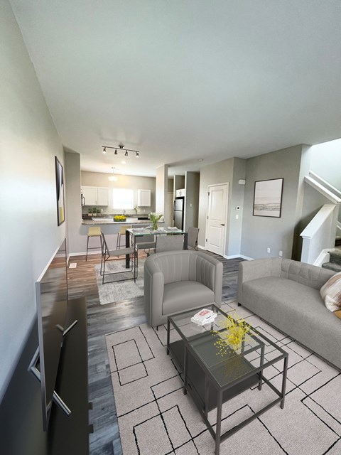 A modern living room with a glass coffee table and a grey couch.