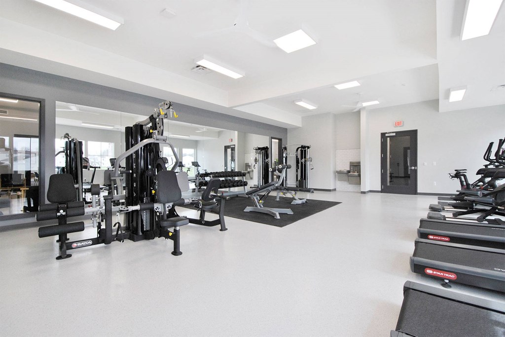 a gym with weights and other exercise equipment in a large room