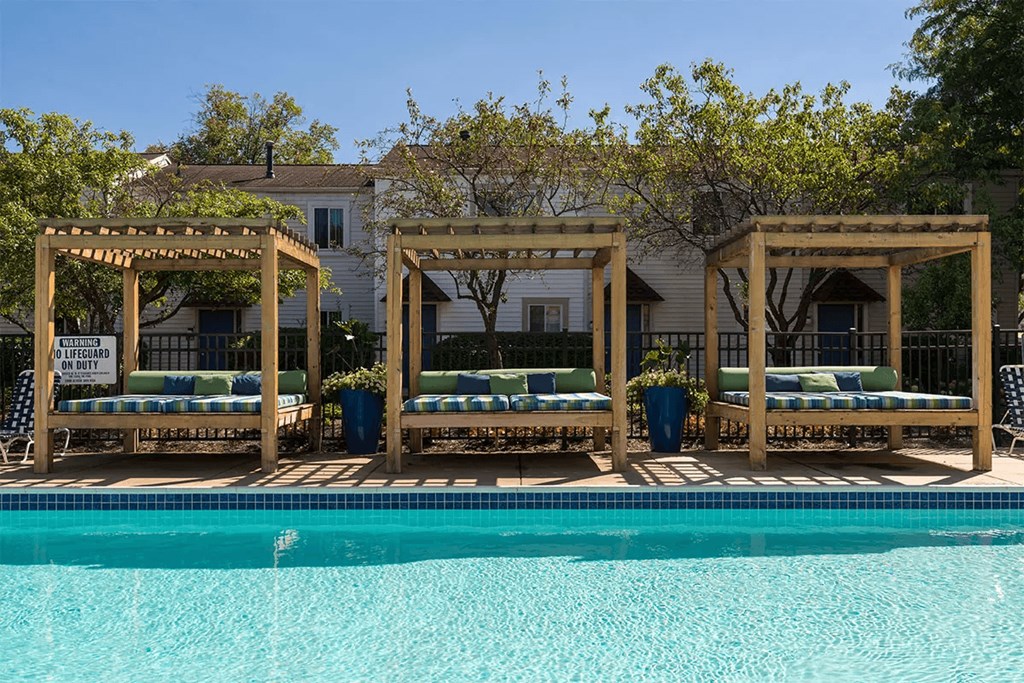 a swimming pool with three sets chairs and a pool