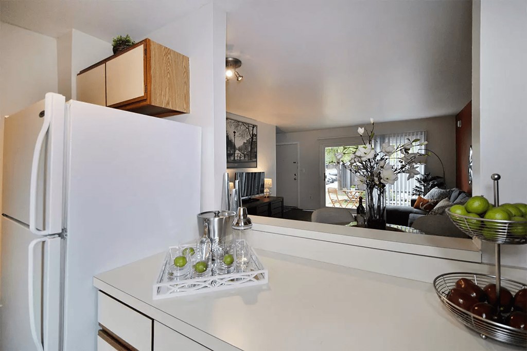 a kitchen with a white counter top and a refrigerator