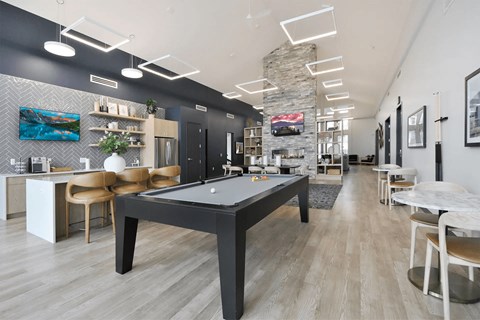 a pool table in a club room with tables and chairs
