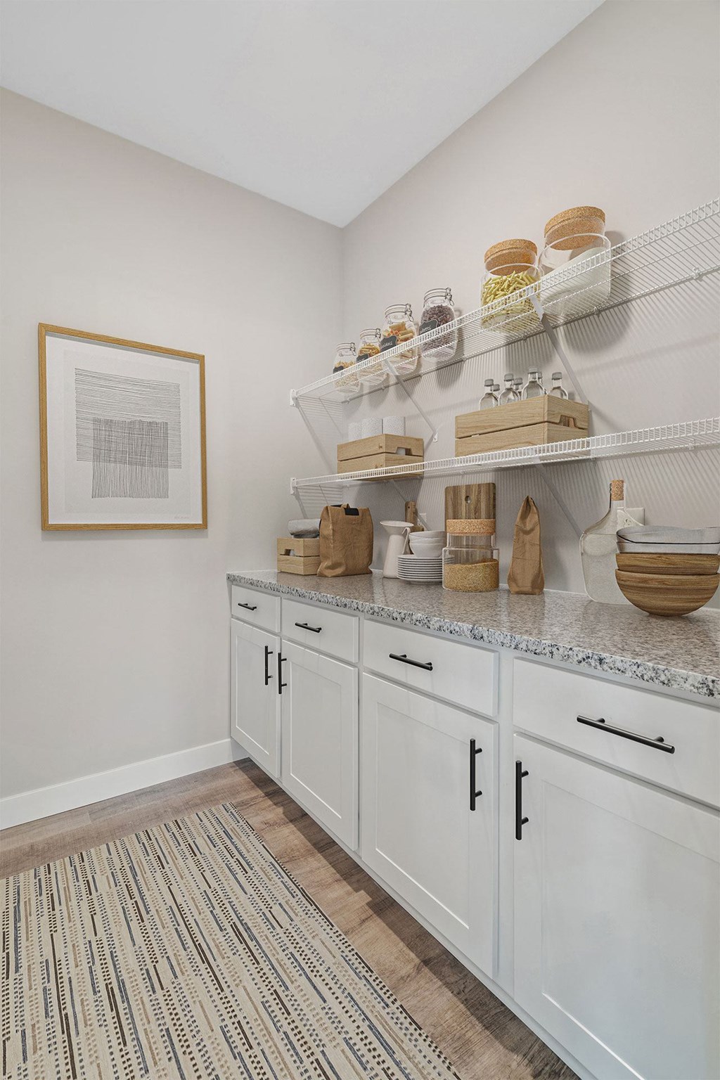 a kitchen with white cabinets and baskets and baskets on shelves