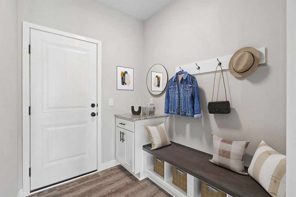 a bedroom with a dresser and a hat on the wall