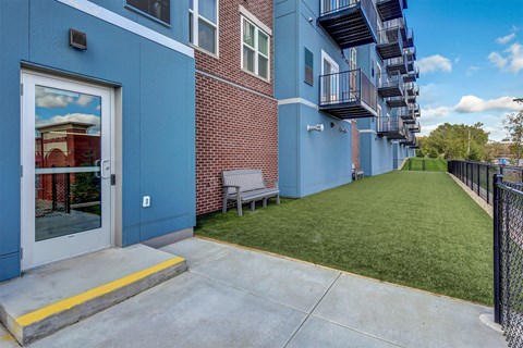 our apartments have an outdoor patio with a lawn and a brick building