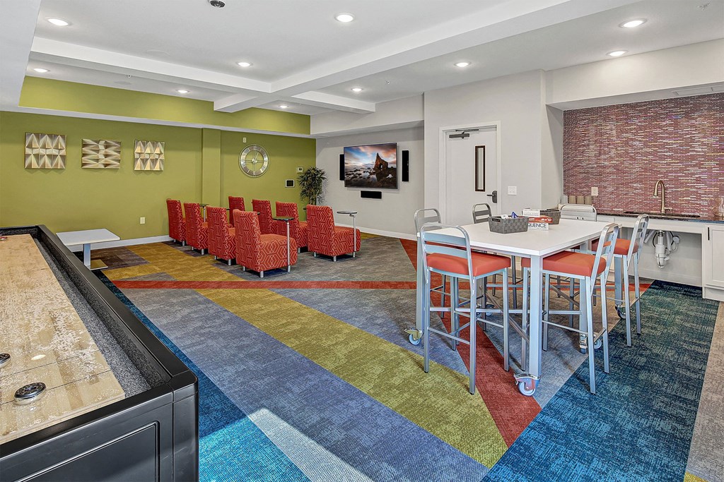 a community room with a table and chairs and a sink