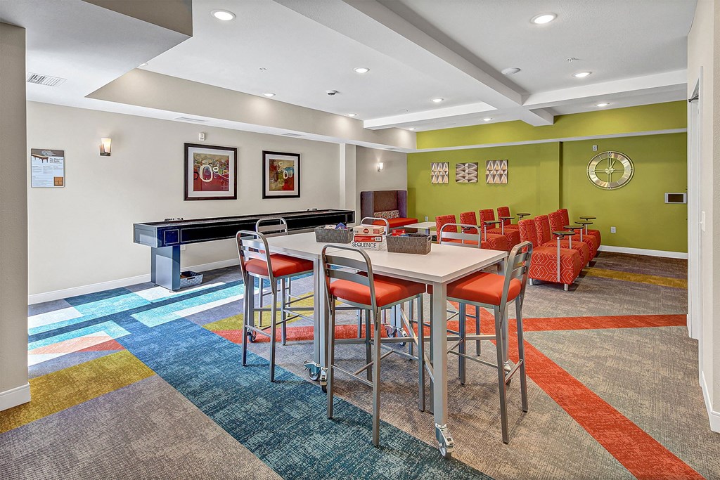 a community room with a table and chairs and a pool table